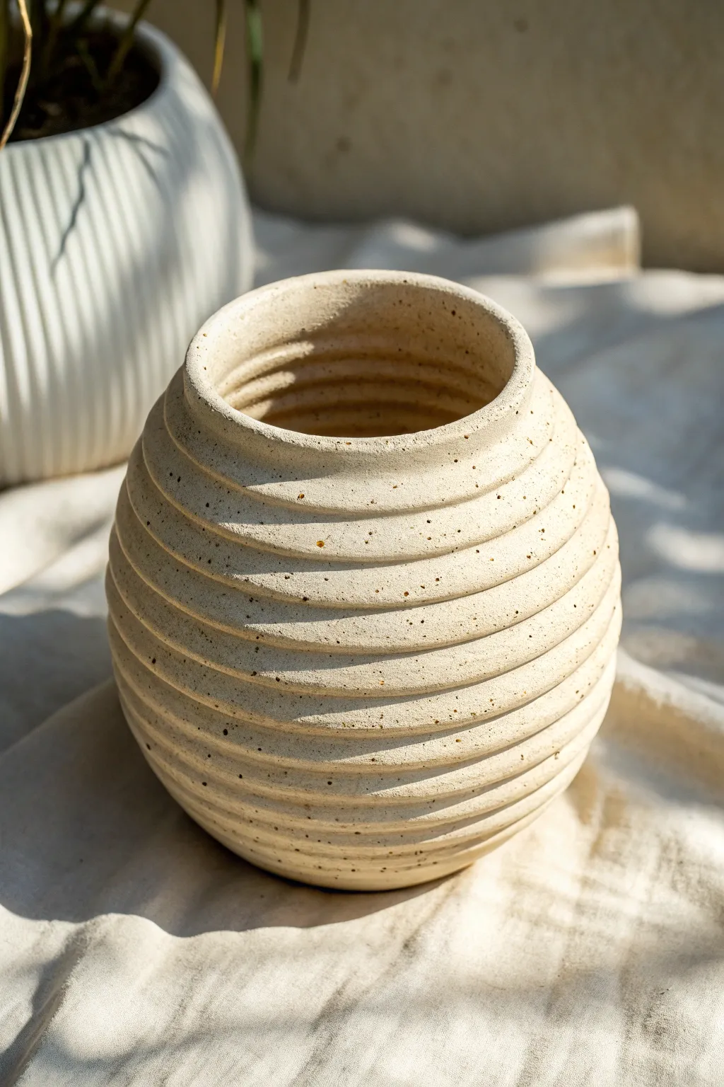 Corrugated coil pot with finger-pinched dimples, softly lit to highlight every handmade ridge