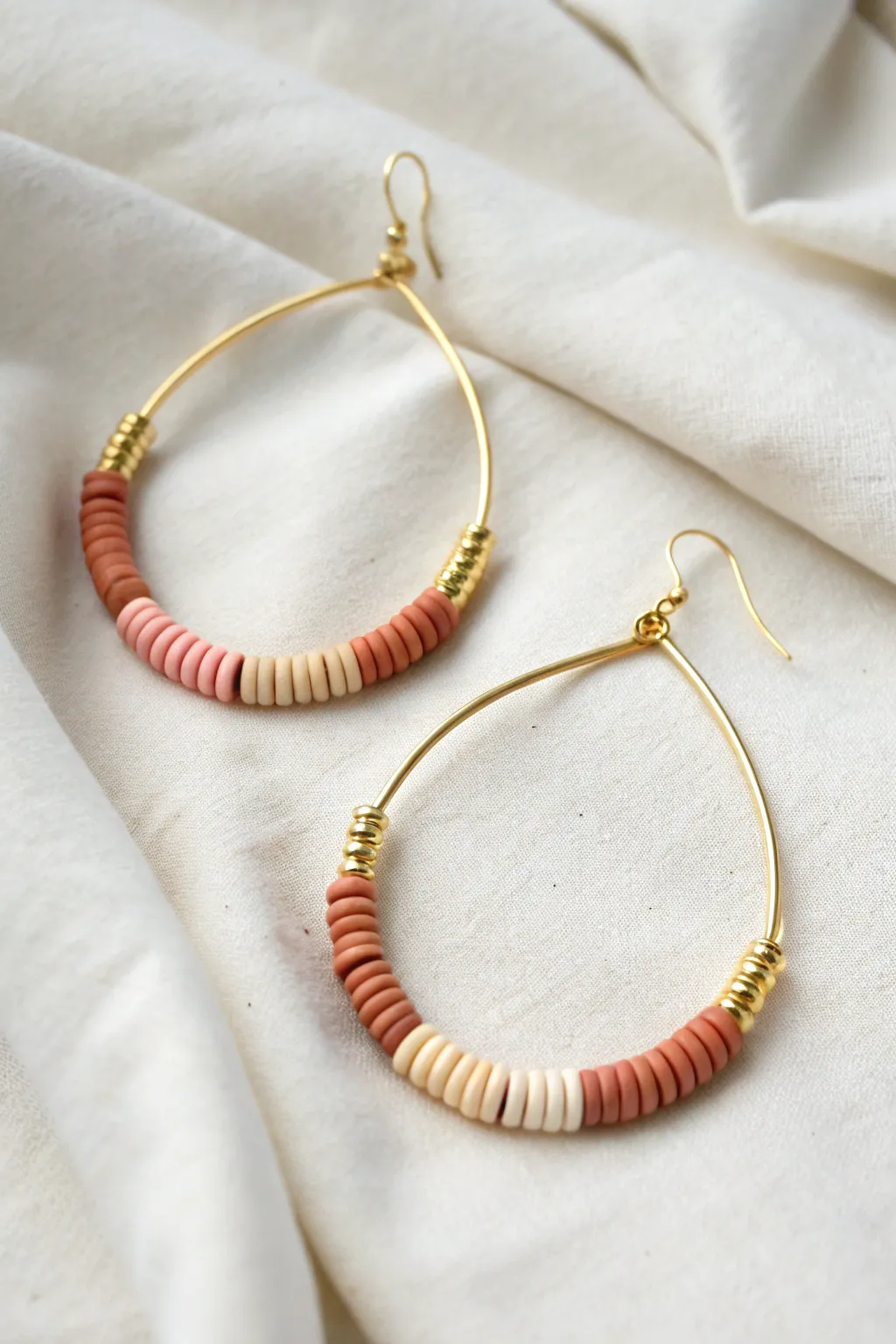 Minimal teardrop hoop with a heishi bead stack at the base for an airy, modern boho look