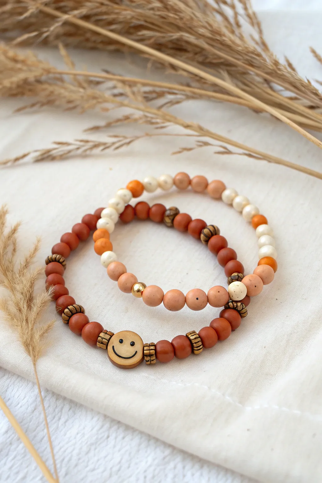 Cheerful autumn clay bead bracelets with orange smiley beads and warm heishi tones.