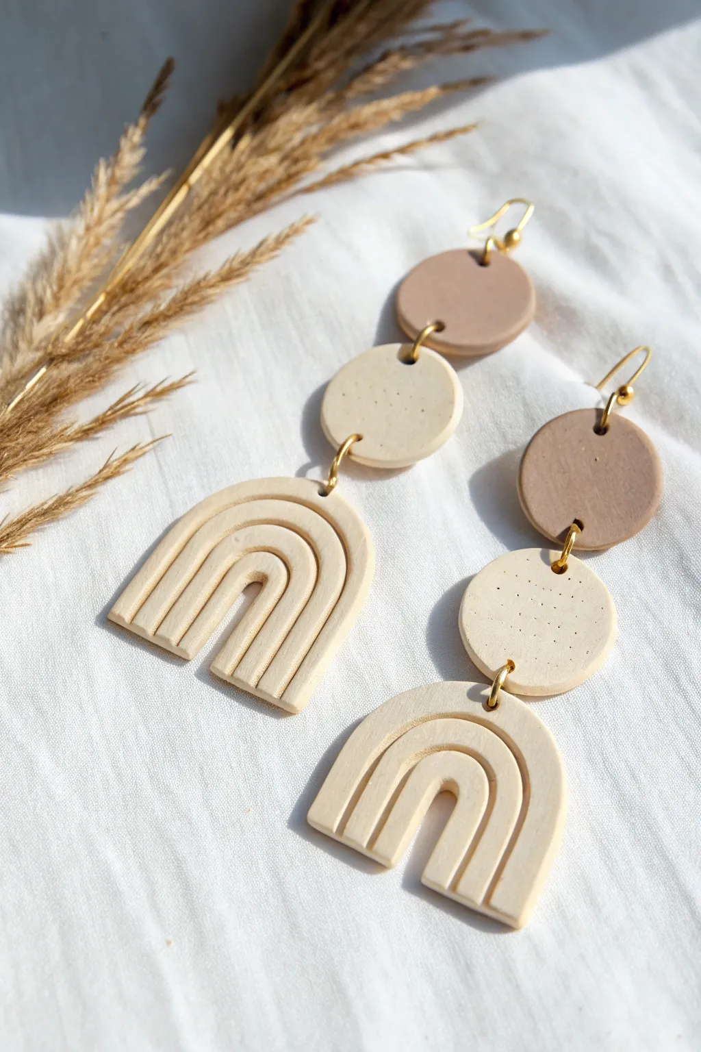 Minimal air dry clay slab earrings in arches and circles, painted in soft neutrals.