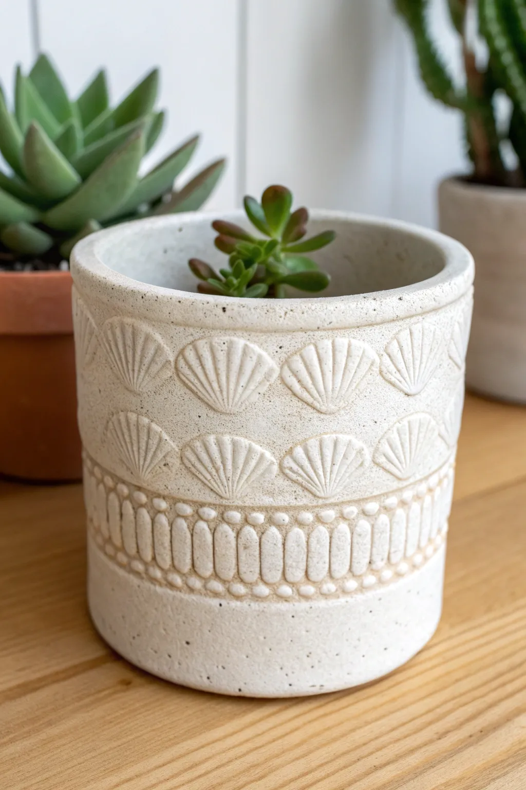 Minimalist clay planter with alternating shell and pebble stamp band for a beachy finish.