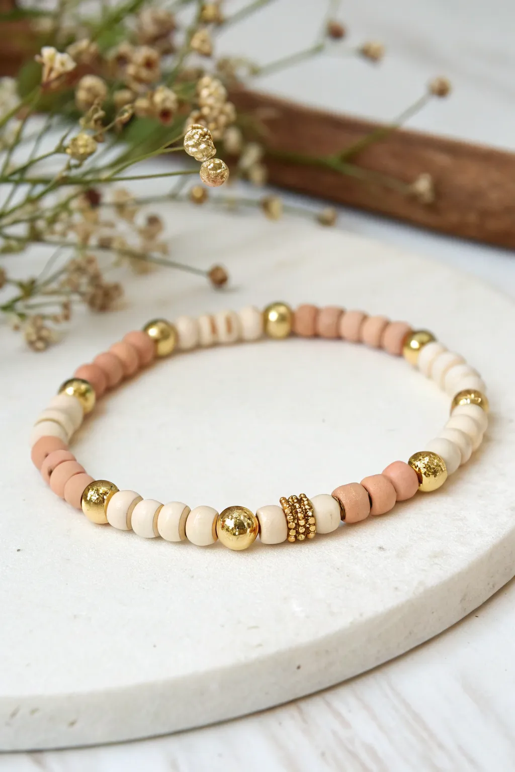 Tiny gold seed beads add a delicate dotted glow between clay bead stacks for an easy luxe look