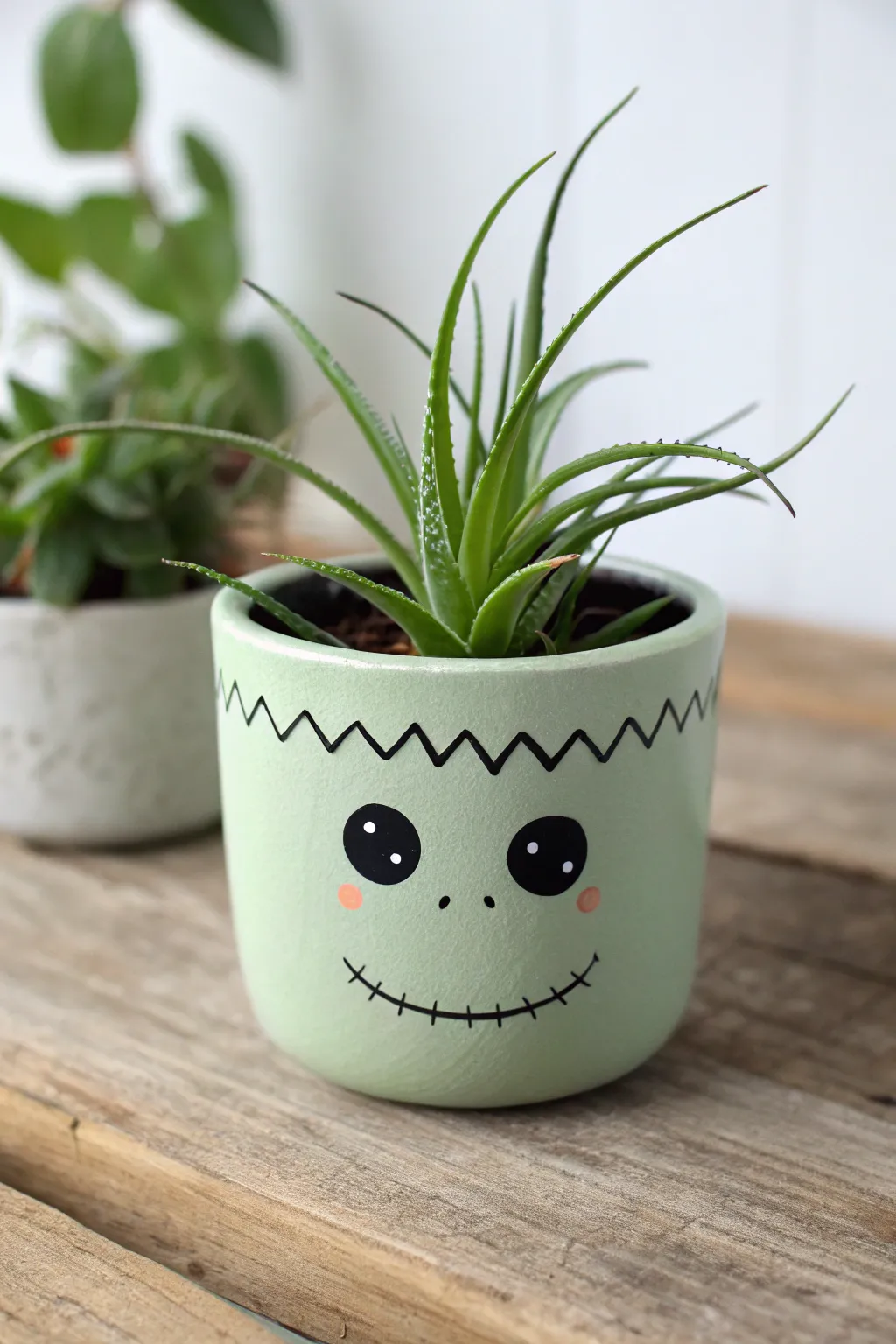 Cute stitched monster face planter with wild green hair for an easy Halloween paint idea