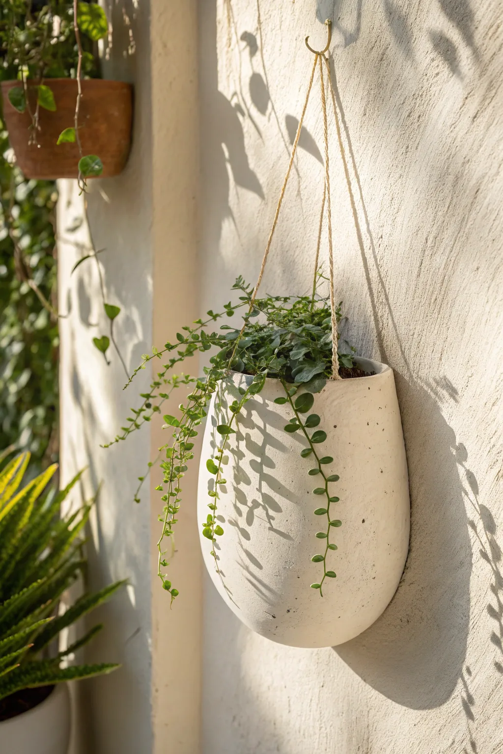 Minimal slab-built wall pocket planter with a trailing vine, soft texture and calm Nordic warmth.