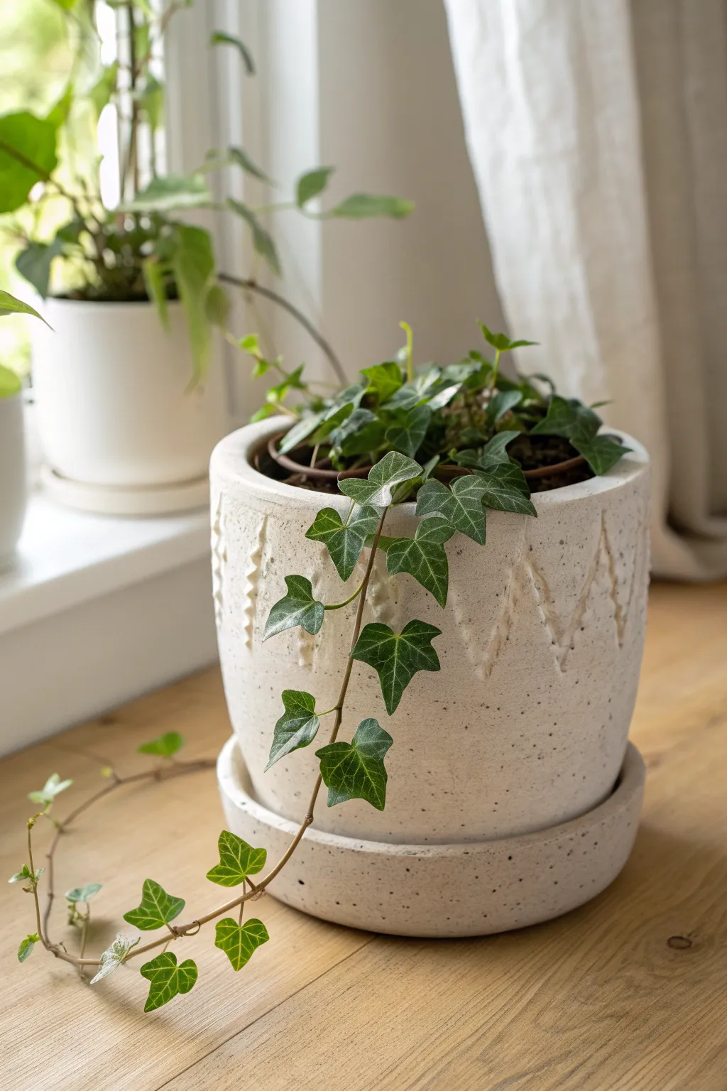 Hand-built stoneware planter with ivy leaf texture and trailing vines for calm, natural style