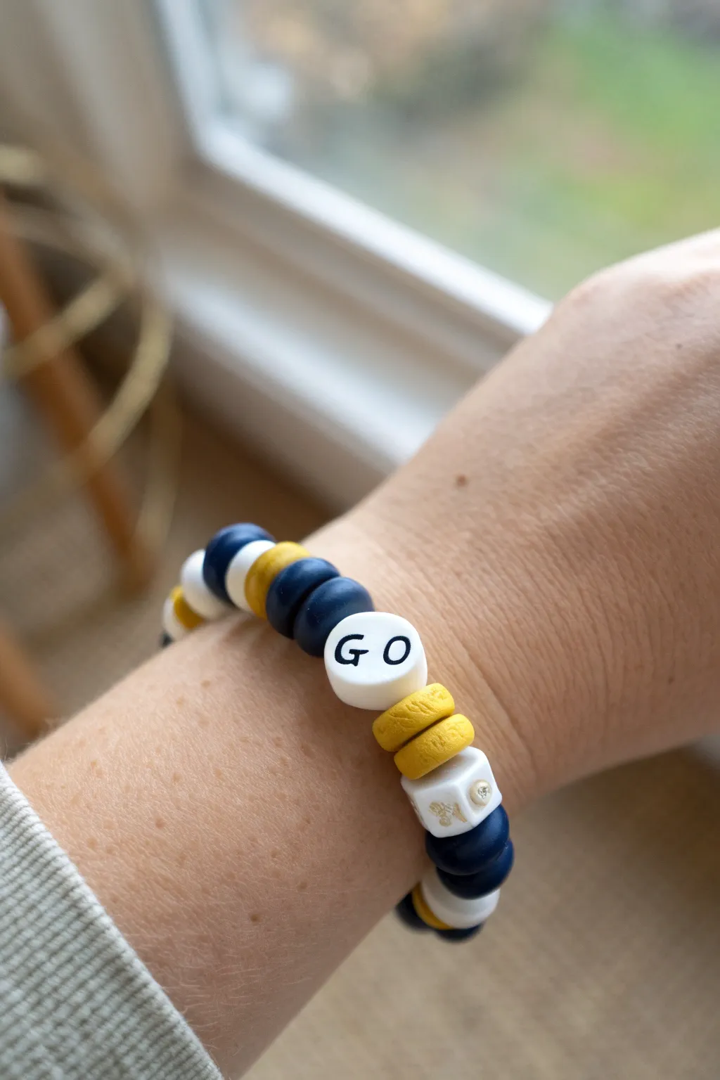 Team color clay bead bracelet with simple letter beads, an easy kids game day accessory