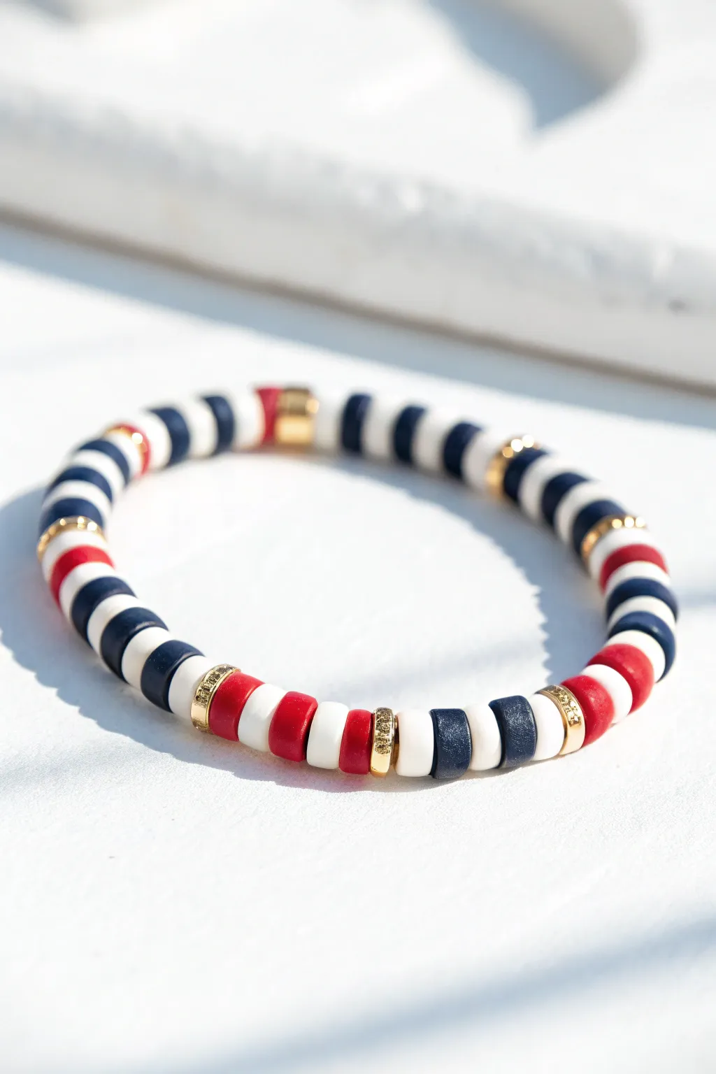 Nautical stripes in navy, red, and white with tiny gold accents for a crisp preppy look.