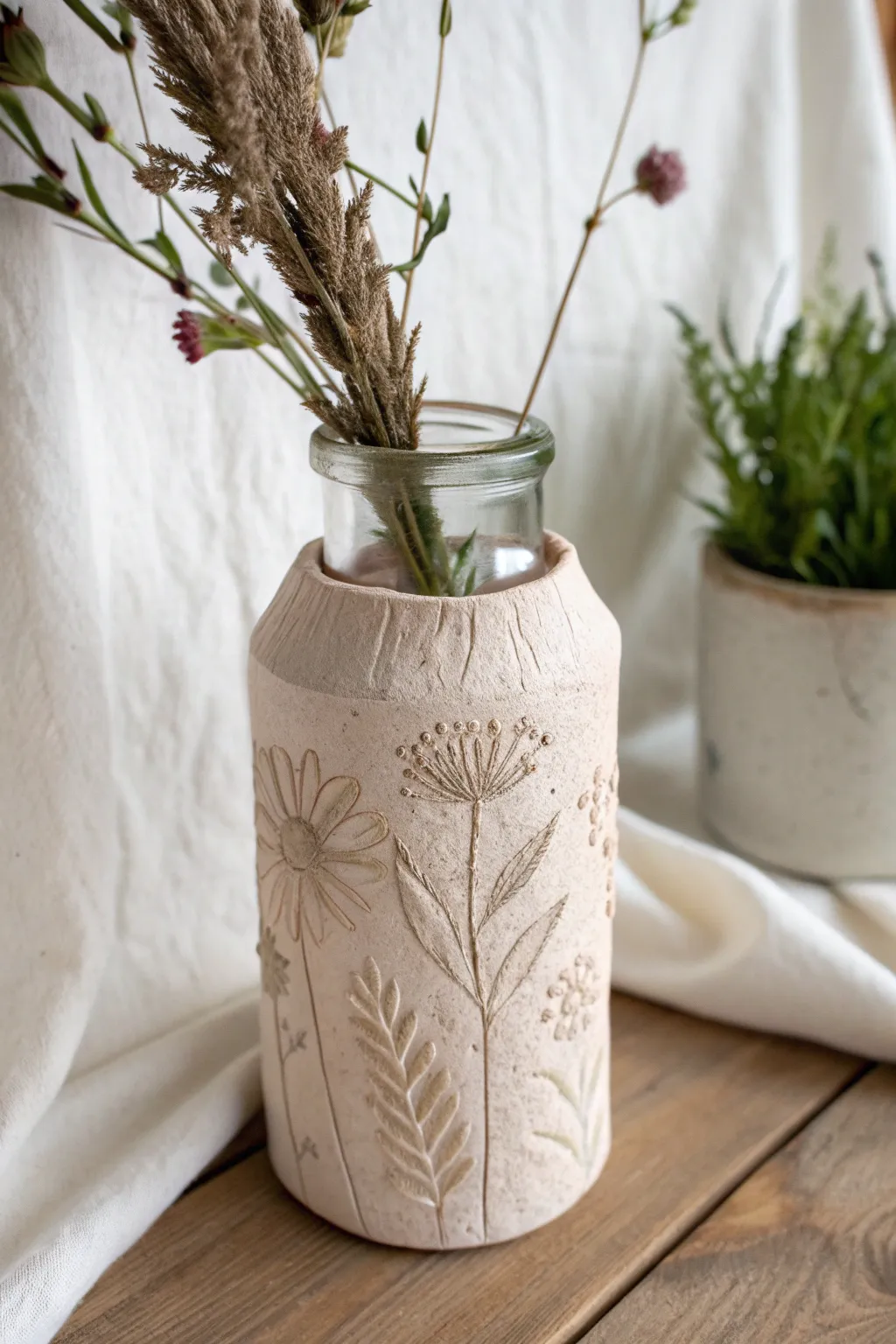 Pressed-flower clay sleeve wraps a simple jar vase for an easy, elegant air-dry decor upgrade