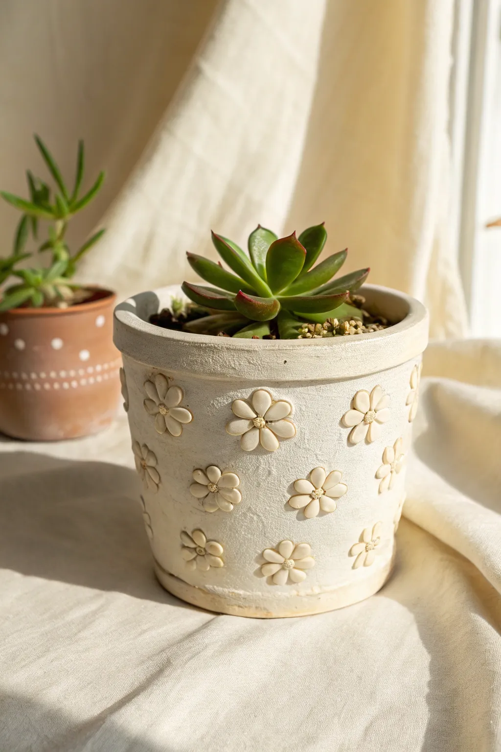 Raised relief flower pot in soft matte tones, styled with a simple succulent for easy charm.