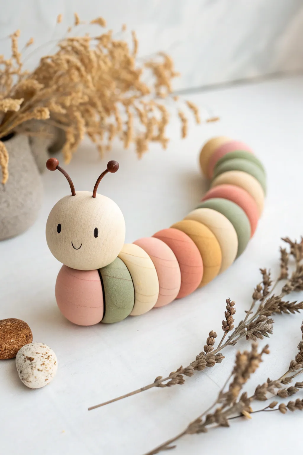Soft color-block clay caterpillar in a gentle curve, minimal Scandinavian boho style