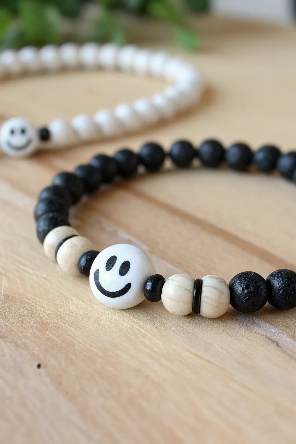Monochrome smiley bead bracelet with simple matching stack, minimalist boho styling.
