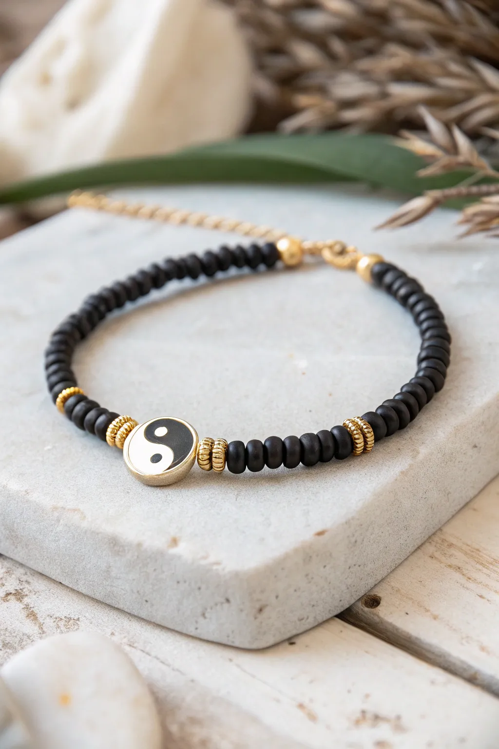 Minimalist black heishi bracelet with a crisp yin-yang focal bead on pale stone