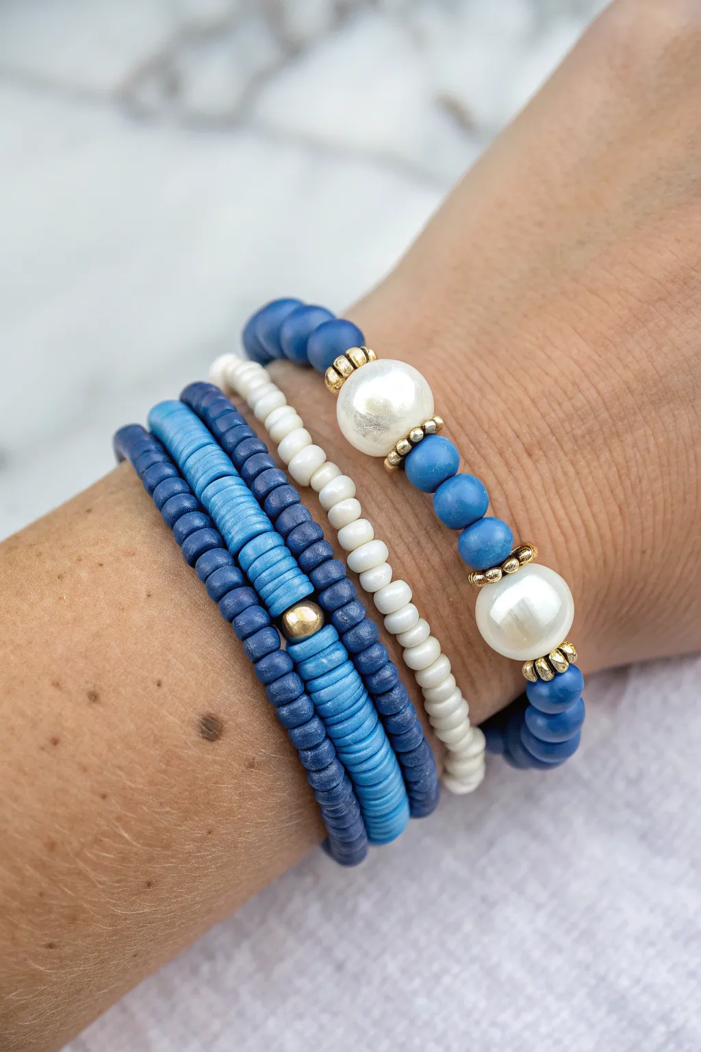 Chunky blue heishi bracelet stack with pearl and oversized bead accents in soft minimalist boho style