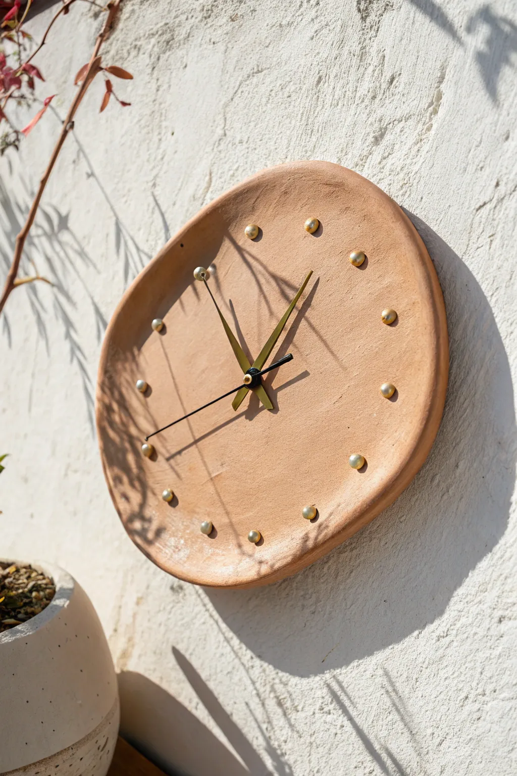 Asymmetrical pebble ceramic wall clock in earthy glaze, minimalist dots, modern Scandinavian boho feel.