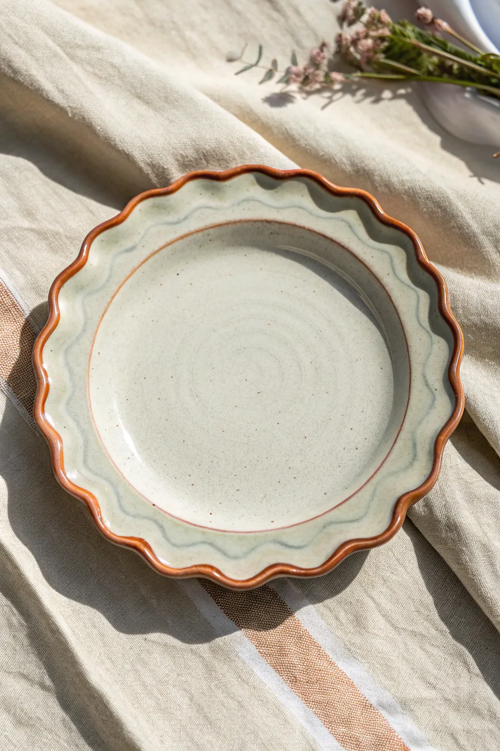 Wavy-edged ceramic plate with a hand-painted scalloped rim, minimalist Scandinavian with boho warmth.