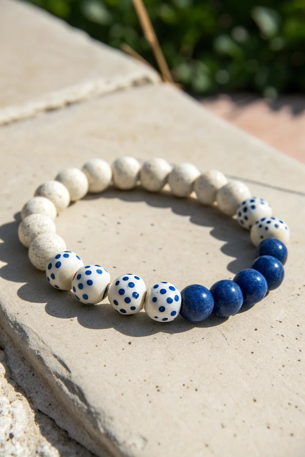 Hand-painted blue dots on white clay beads, mixed with solid blue beads for a fresh coastal look.