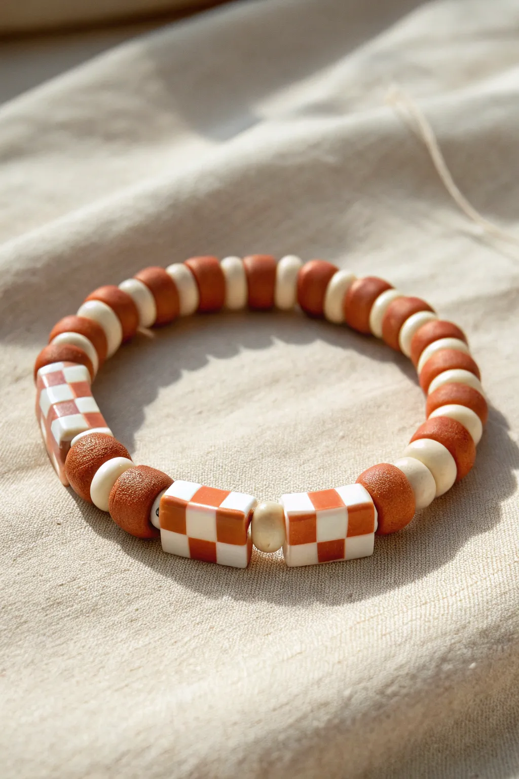 Checkerboard disc bead bracelet in terracotta and cream, minimalist and handmade.