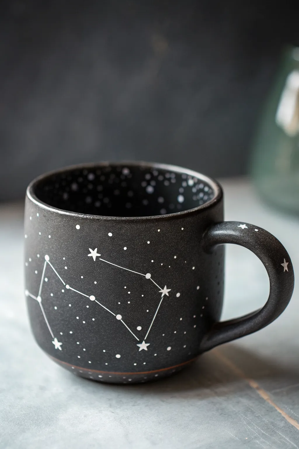 A moody constellation-dotted cup with crisp white stars for an easy celestial pottery look.