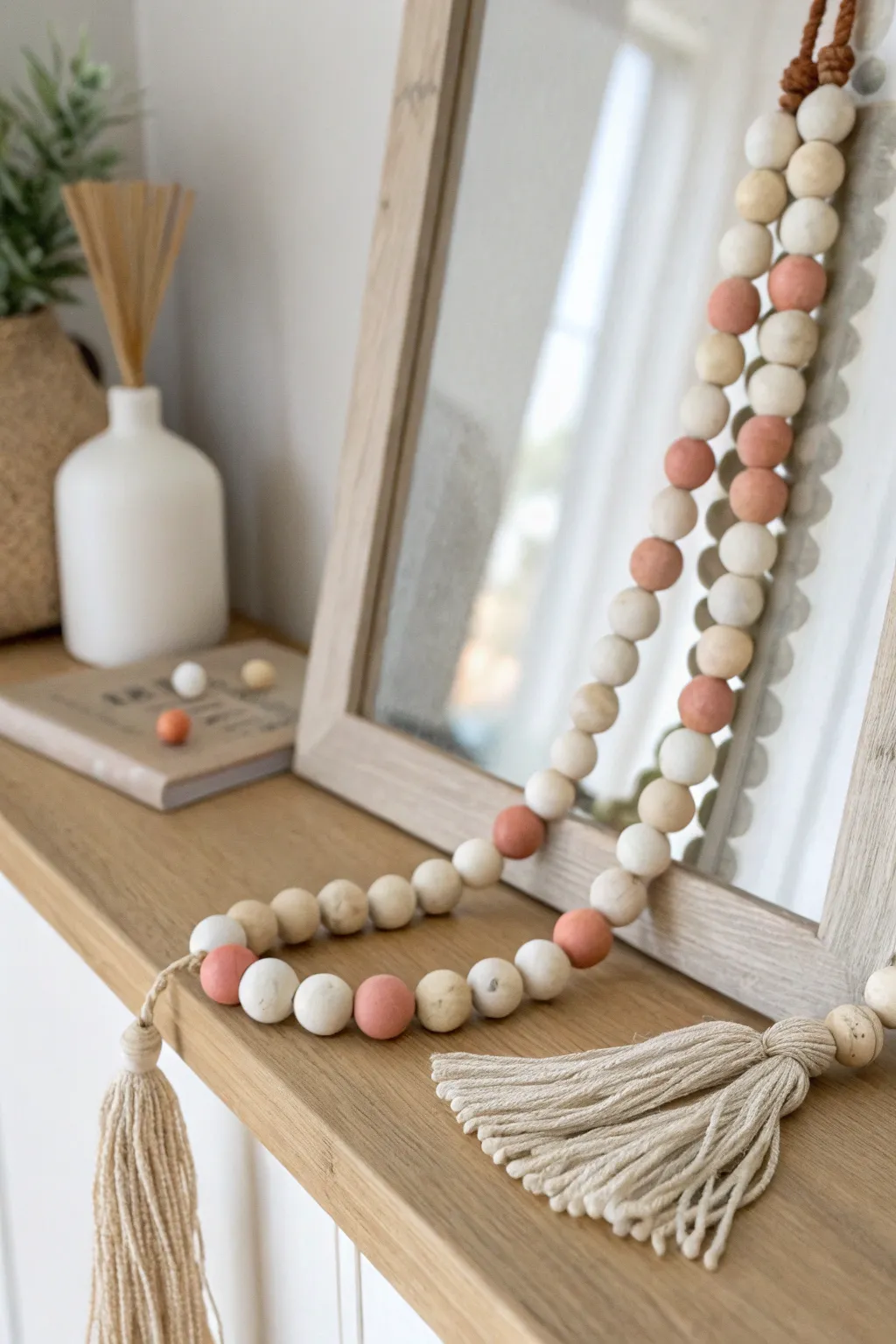 Soft neutral clay bead garland draped on a mirror, minimalist boho charm for calm rooms
