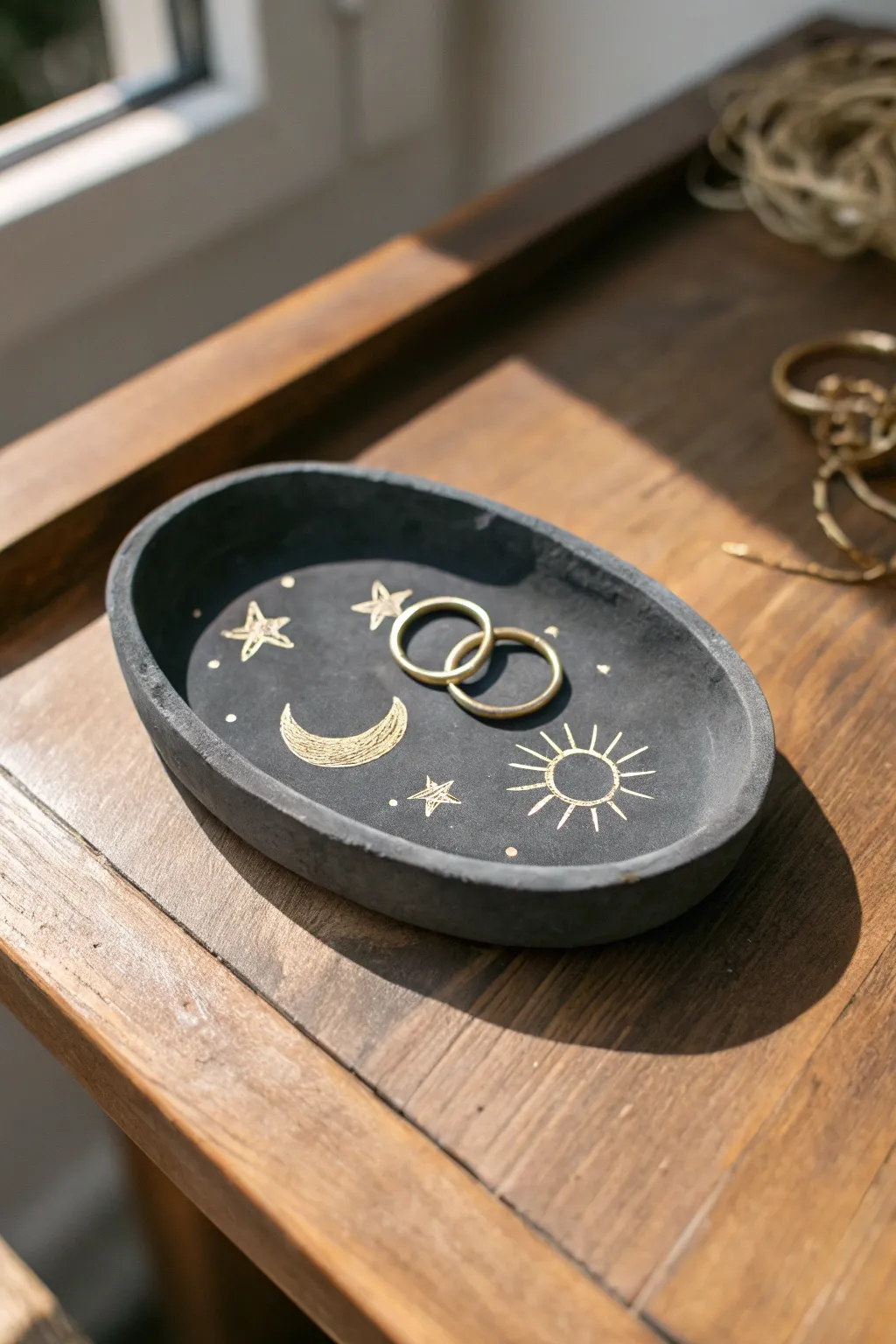 Celestial sun and moon clay tray in deep charcoal, a minimalist spot for your favorite rings.