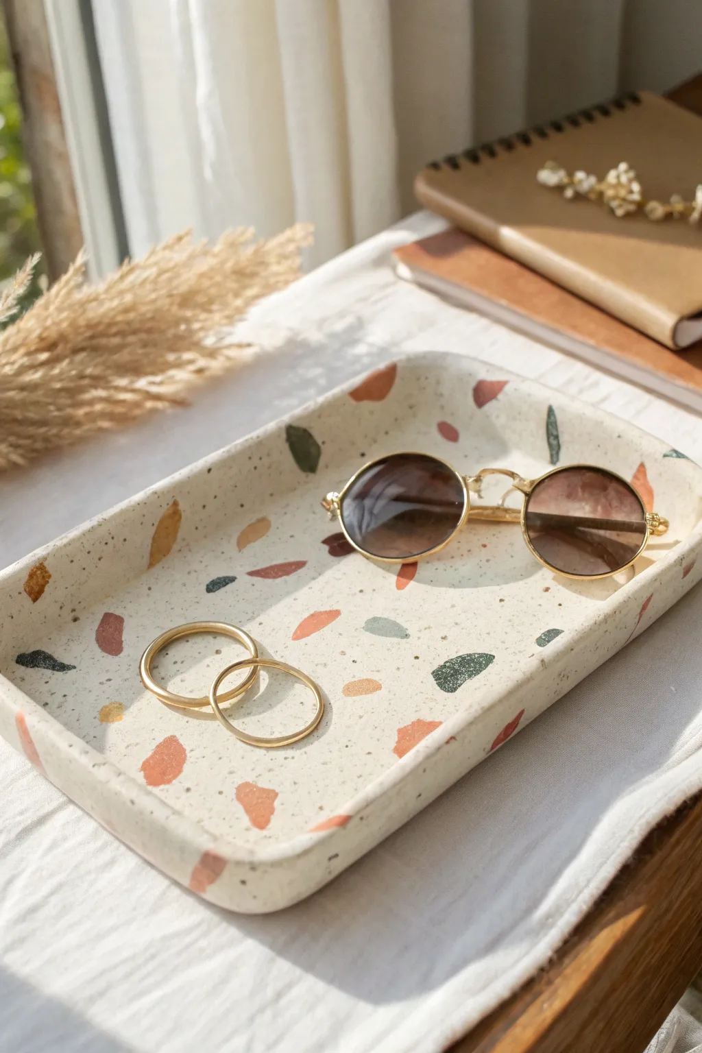 Terrazzo clay trinket tray for rings and sunnies, minimalist boho styling in soft daylight.