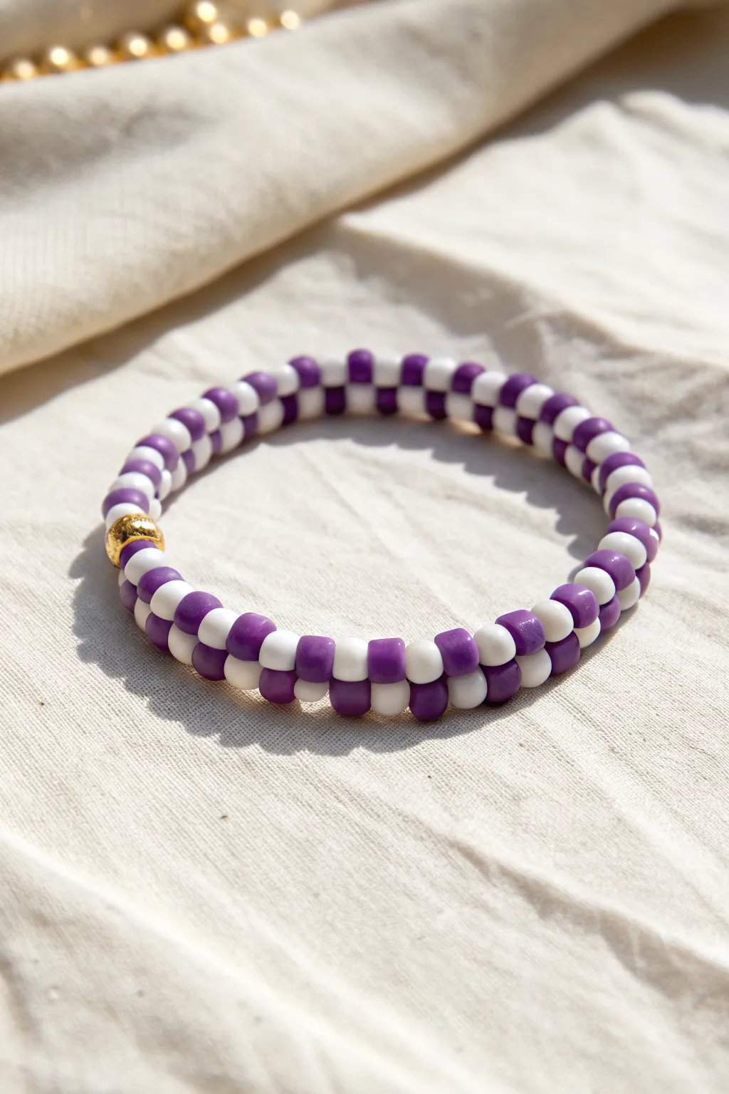 Purple checkerboard clay bead bracelet on a bright backdrop for a crisp, modern boho look.