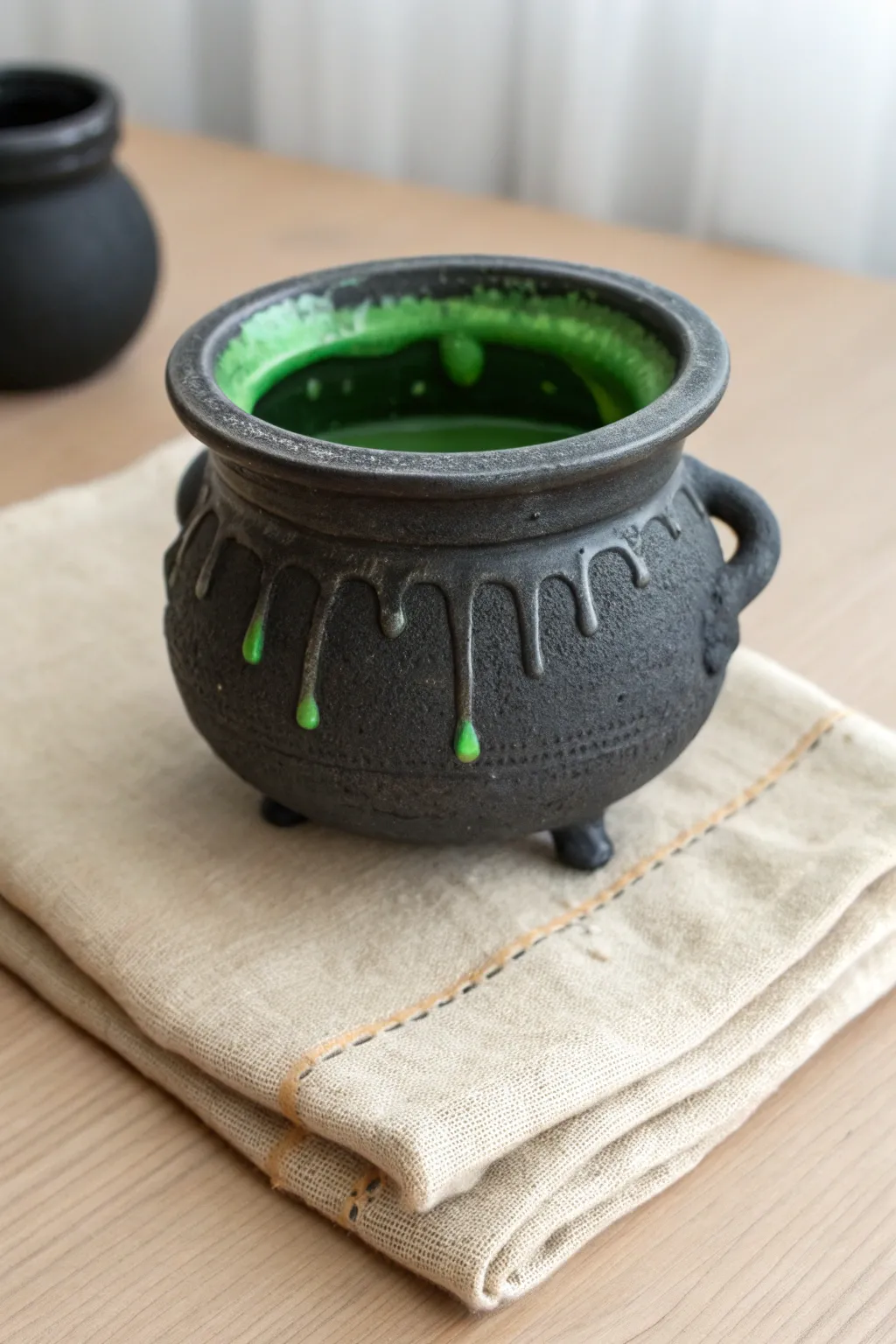 Minimalist Halloween cauldron pot with neon green bubbling rim and simple drips for drama