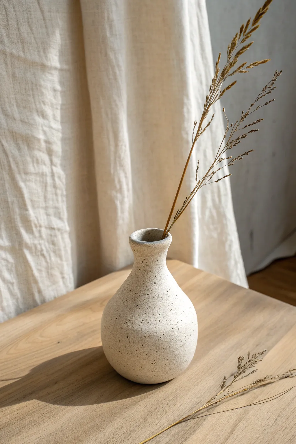 Simple joined pinch pot bud vase with a single stem, minimal and handmade beauty.