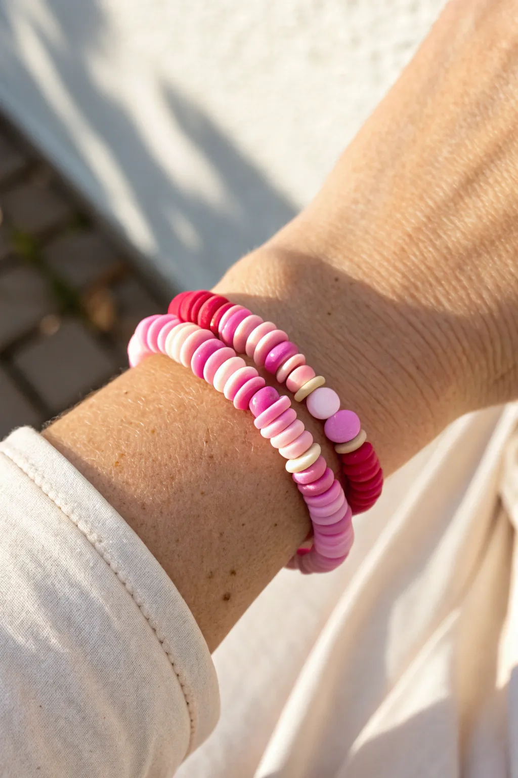 Random pink confetti disc bead bracelet, playful yet minimalist, glowing in sunny Scandinavian light