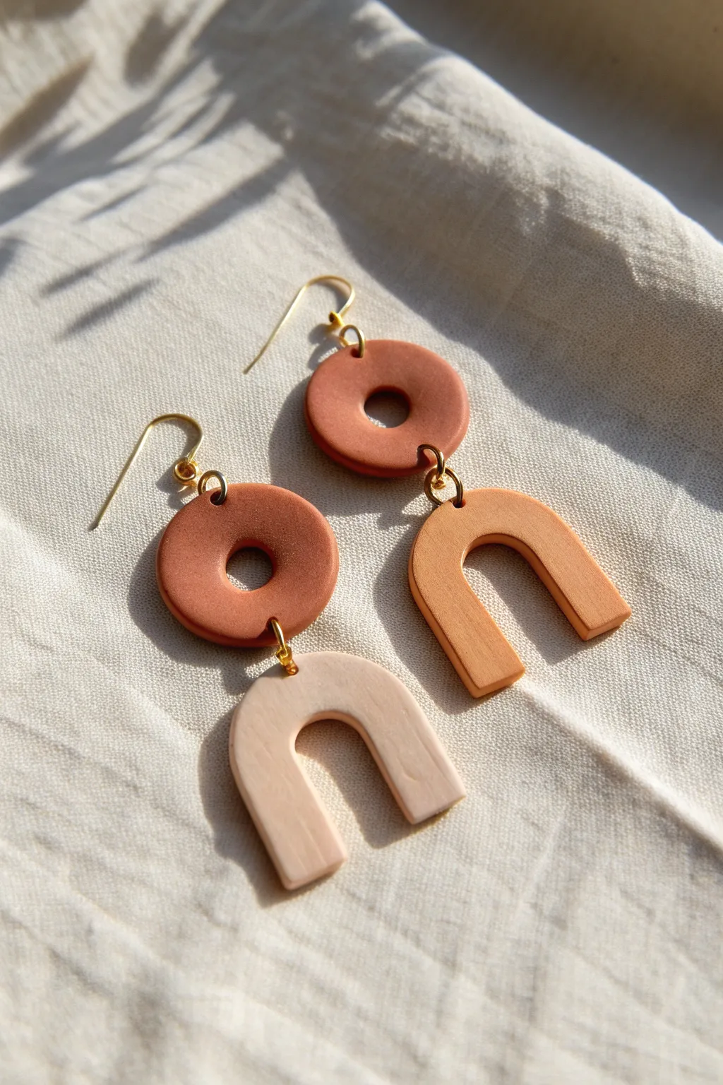Modern polymer clay cutout earrings with crisp shadows that highlight airy negative space