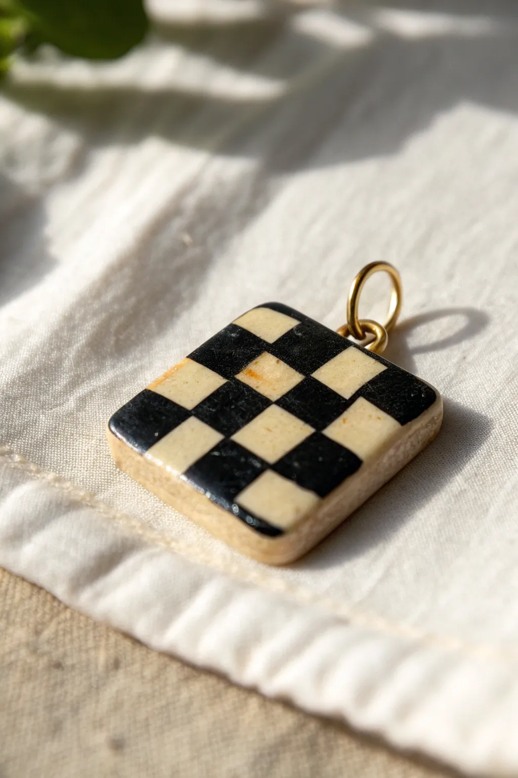 Minimal polymer clay checkerboard tile charm, crisp contrast and cozy handmade texture.