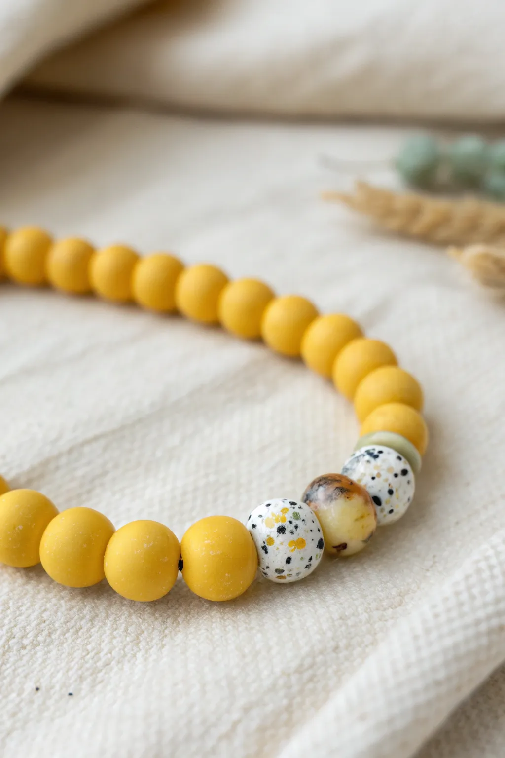 Terrazzo-speckled yellow clay bead bracelet with minimalist Nordic-boho charm and texture.