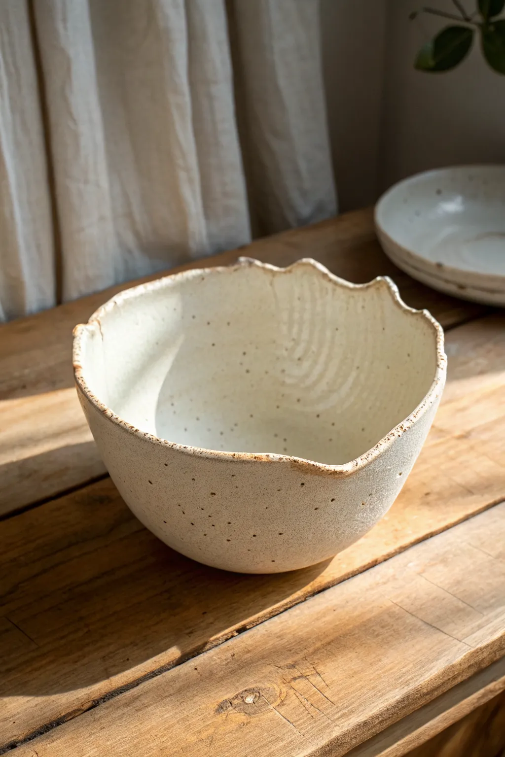 Asymmetrical torn rim bowl in matte speckled stoneware, minimal form with sculptural edge.