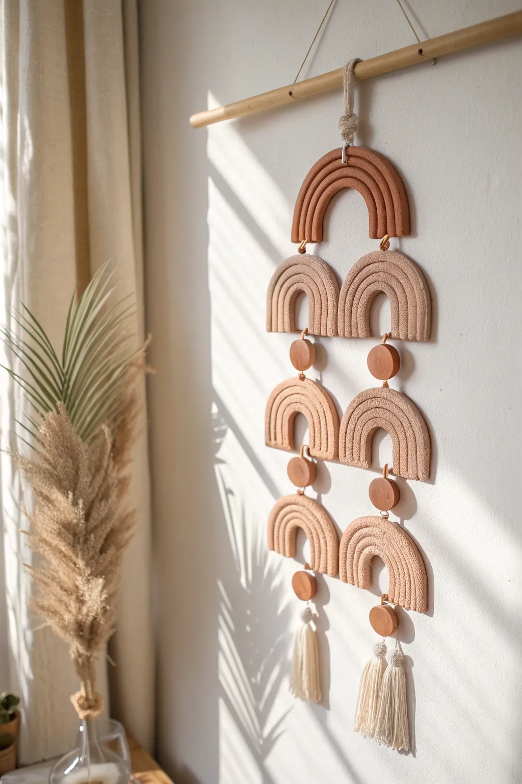 Quiet-toned air dry clay wall hanging with arches and circles, minimalist boho and soft shadows