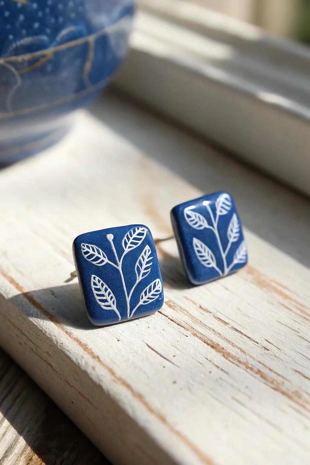 Cobalt blue tile stud earrings with delicate white lines for a crisp minimalist look
