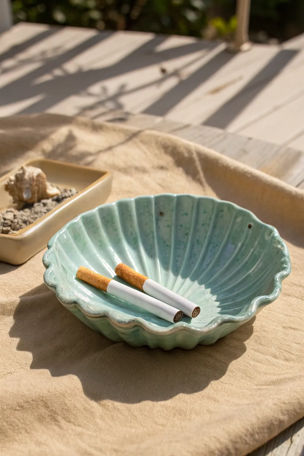 Fluted shell-inspired ashtray in sea-glass glaze, minimalist beach tones and handcrafted charm.