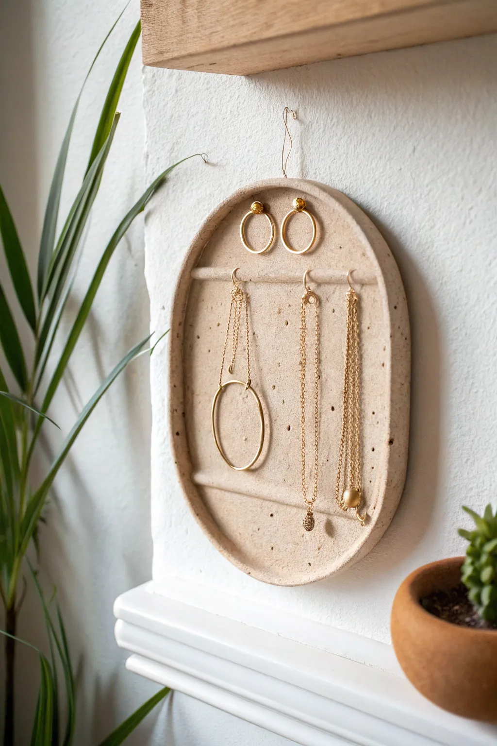 Minimal wall-mounted clay peg holder that keeps necklaces and hoops tidy in a calm, neutral style