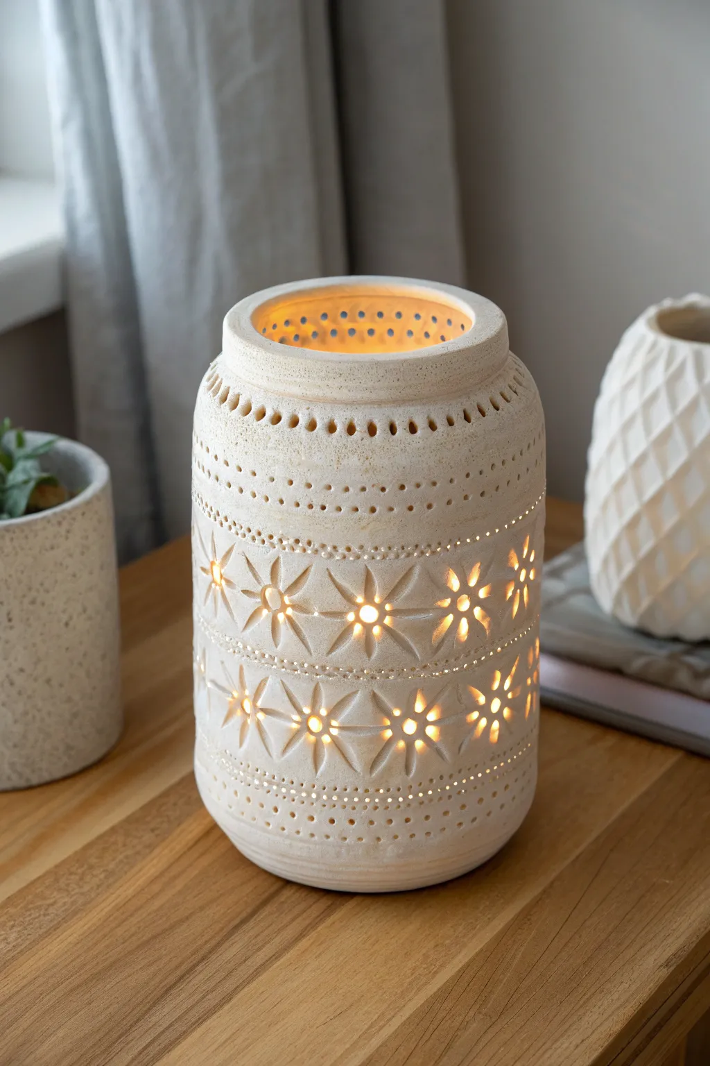 Softly glowing textured clay lantern with punched accents, minimalist boho warmth for cozy nights.