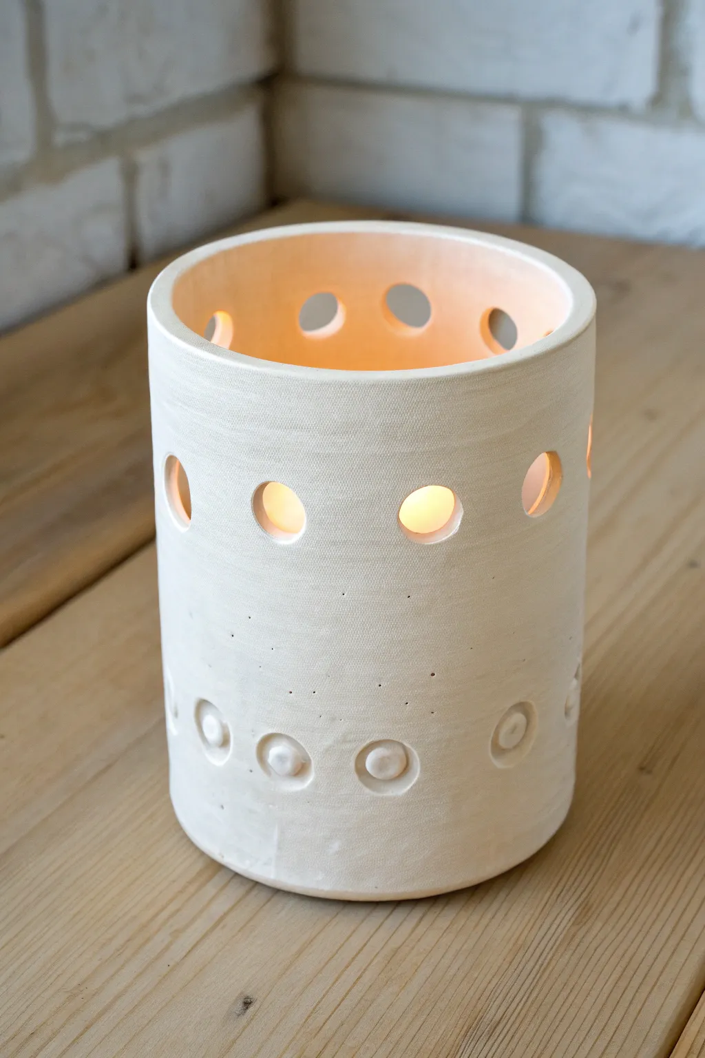 Porcelain-thin clay luminary with tiny cutouts, glowing softly for a calm, cozy ambiance.