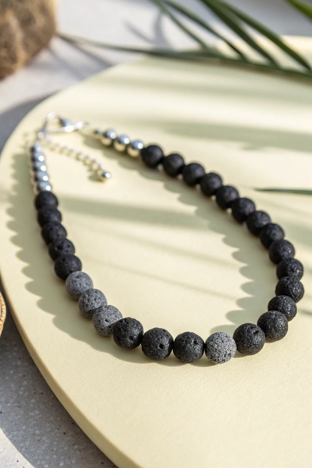 Matte lava rock bead necklace in charcoal tones, minimalist boho style with raw volcanic texture.