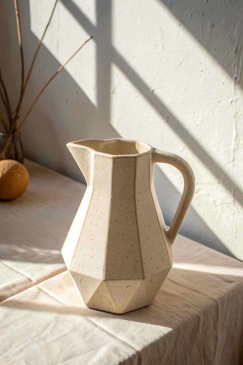 Faceted clay pitcher with crisp planes, side-lit to reveal bold shadows and handmade charm.