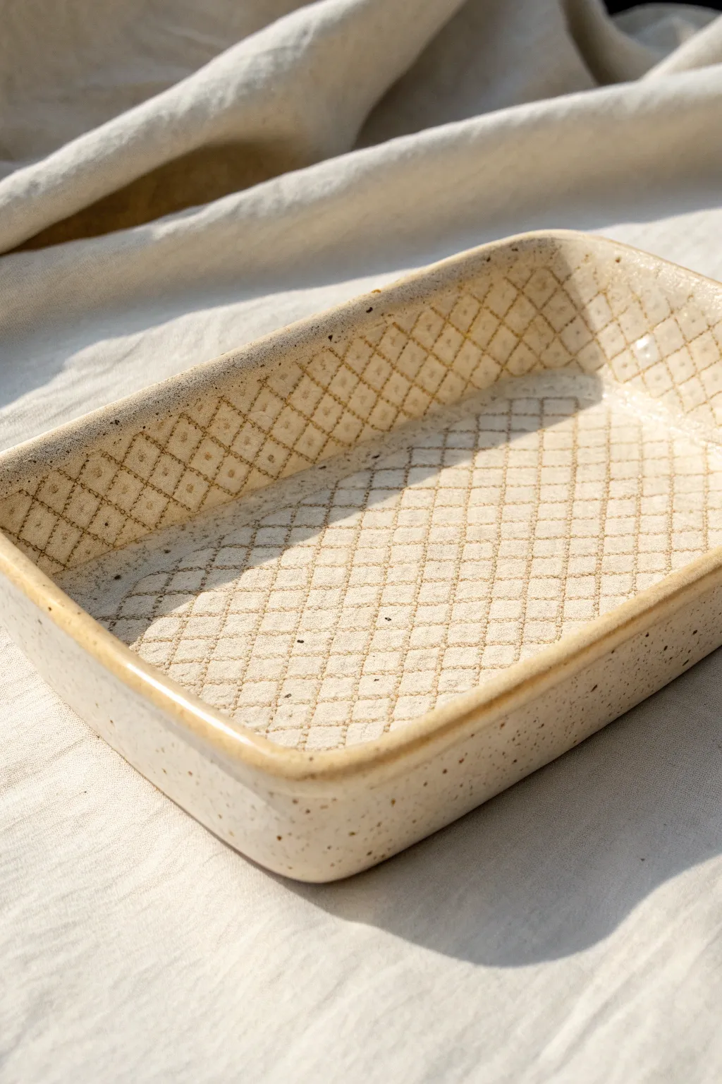 Minimal ceramic tray with crisp diamond net imprint, soft ivory glaze and cozy natural light