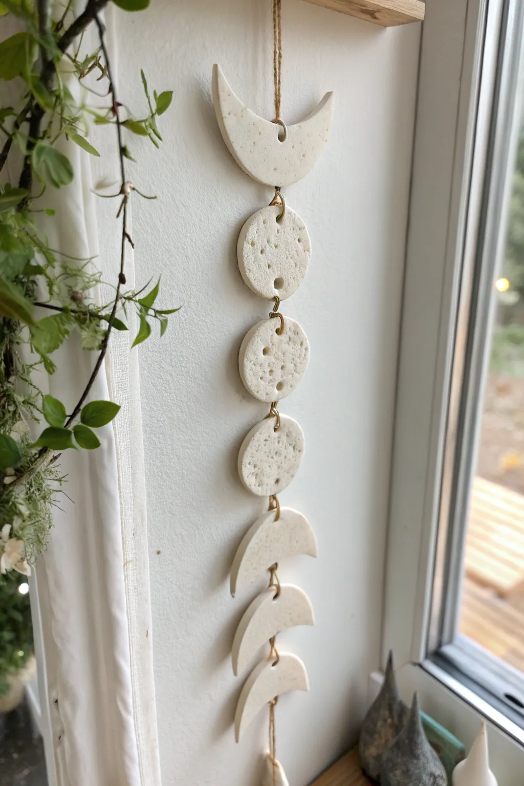 Minimal air dry clay moon phase wall hanging in soft light, simple boho Scandinavian decor