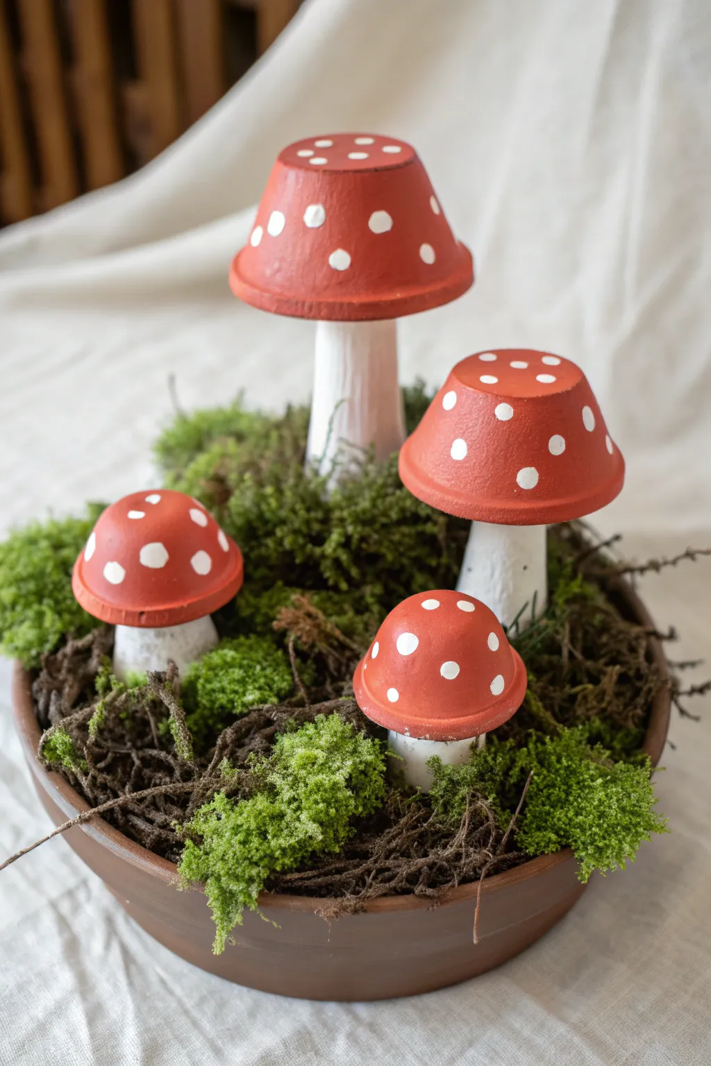 Tiny clay pot mushroom cluster in moss, bold red caps and clean minimalist fairy garden vibes