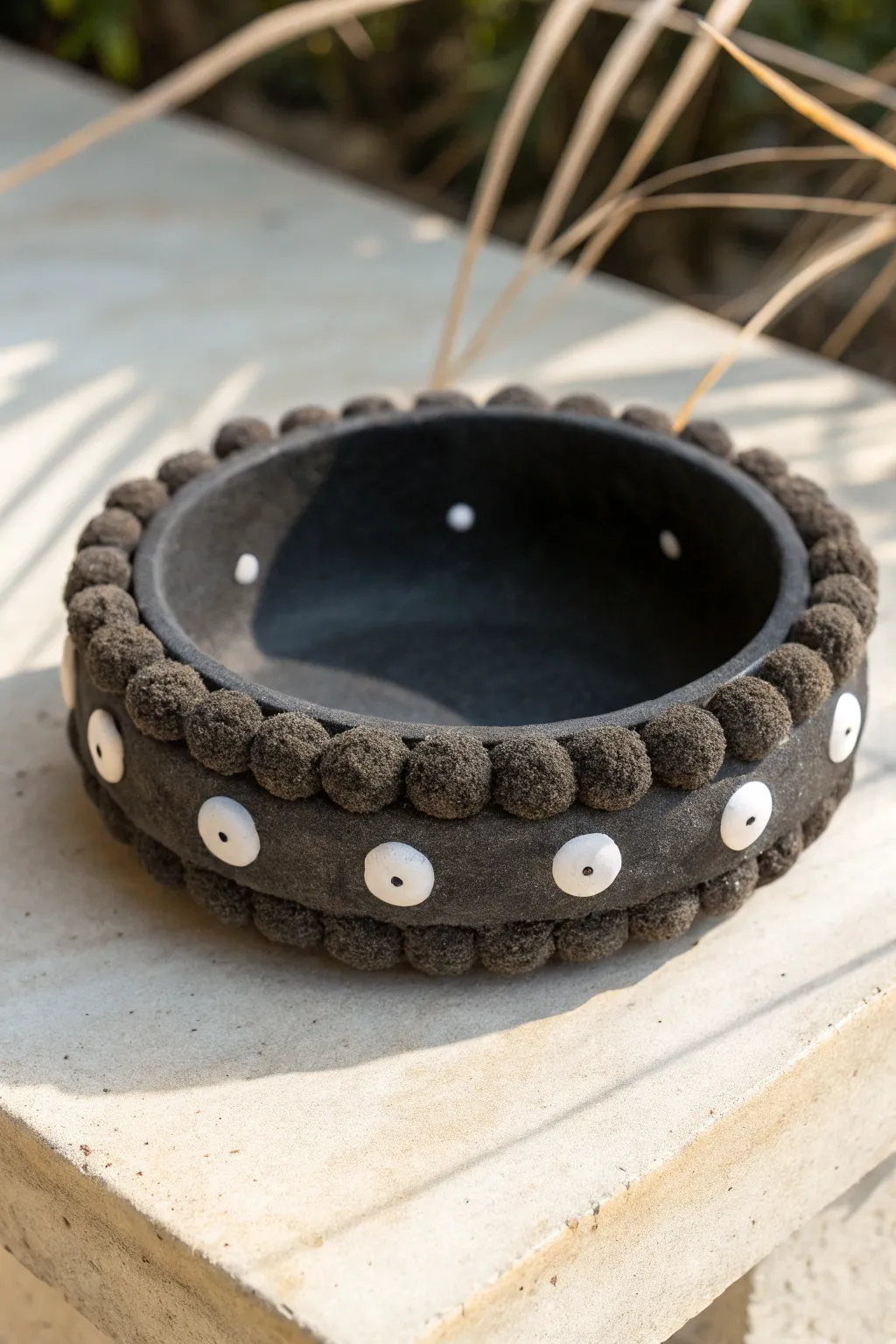 Dust bunny eyeball ashtray: fuzzy bumps, bright eyes, smooth center for easy clean-up.