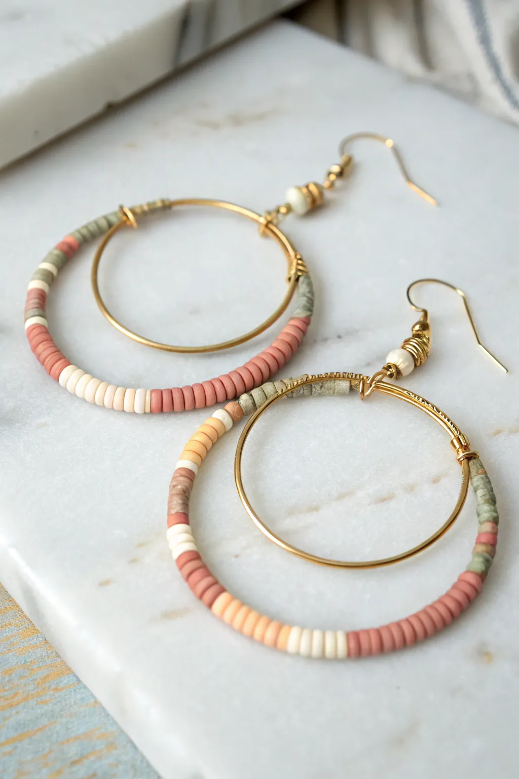 Double hoop clay bead earring with layered heishi discs in soft boho neutrals, minimalist charm