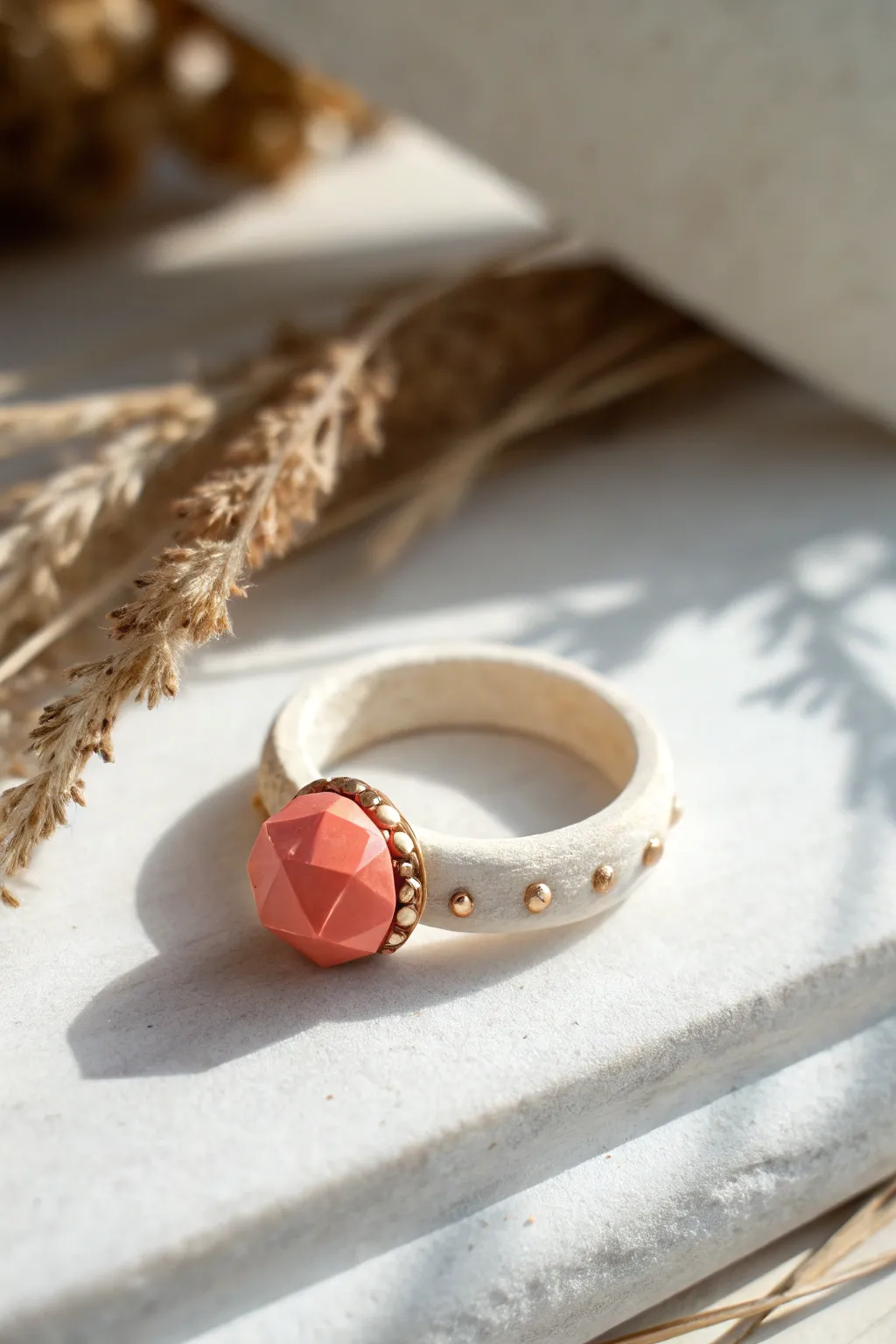 Geometric candy gem clay ring in coral with tiny metallic dots, minimal flat lay inspiration.