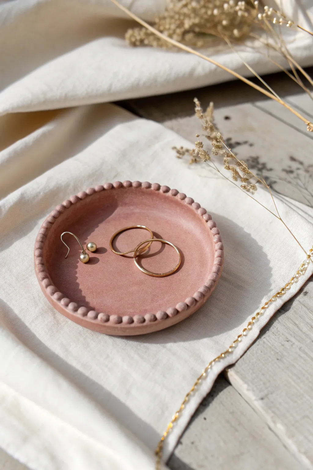 Minimal air-dry clay beaded trinket plate in matte blush, styled with rings and clips