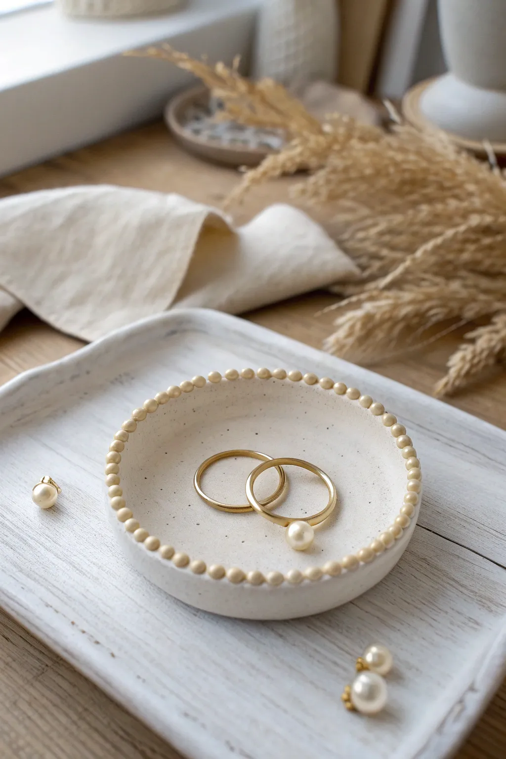 DIY beaded-edge trinket dish in soft clay tones, perfect for storing your everyday earrings.