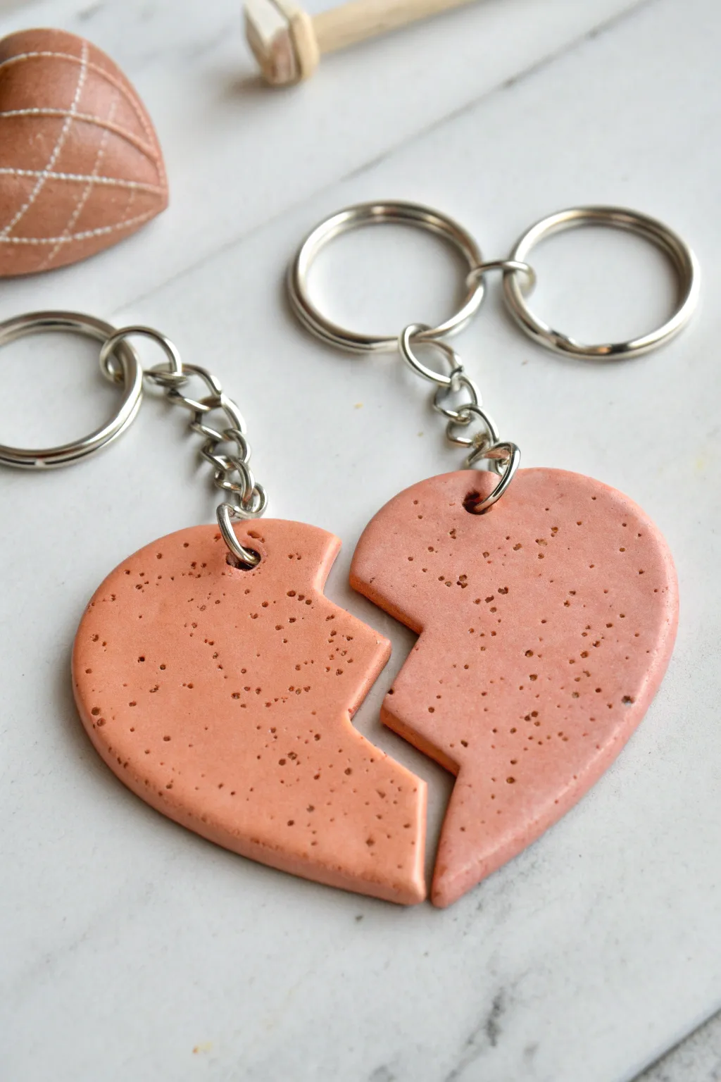 Two foam clay bestie heart keychains, perfectly matched halves in soft blush and terracotta tones